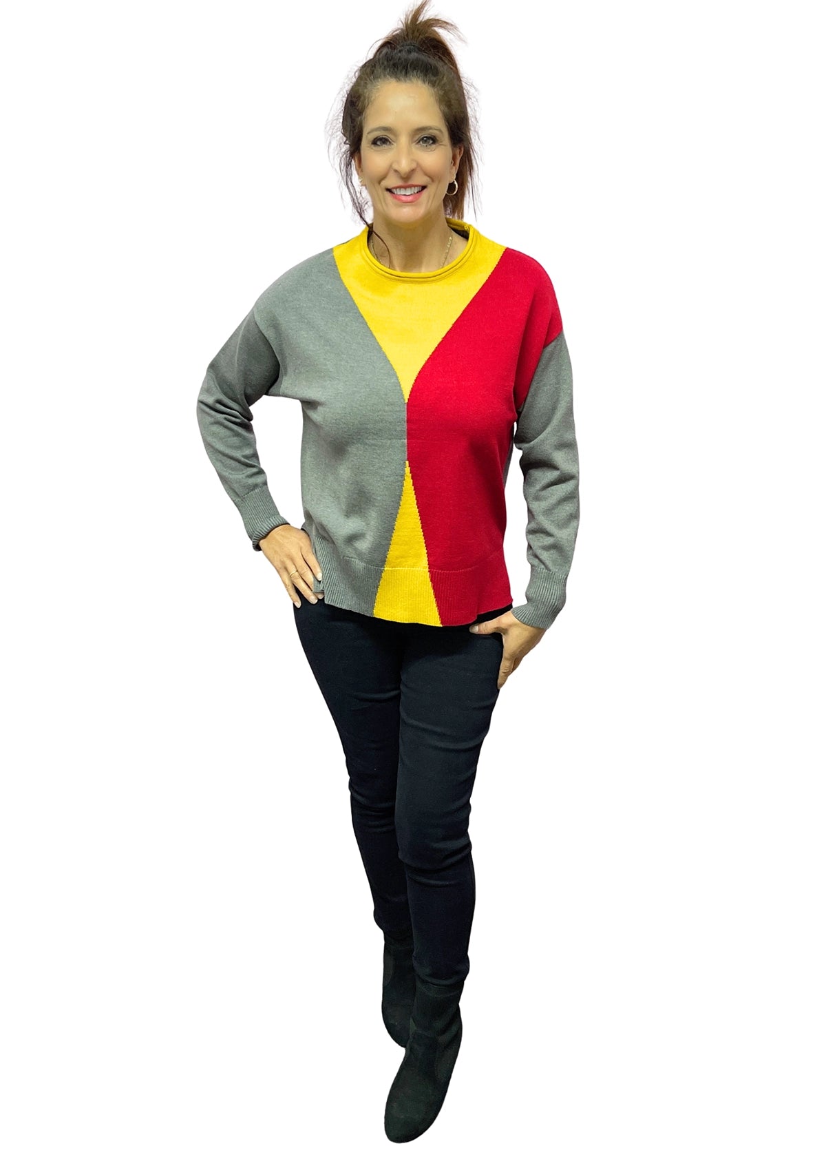 Woman wearing a colorful sweater with gray, yellow, and red sections on a white background