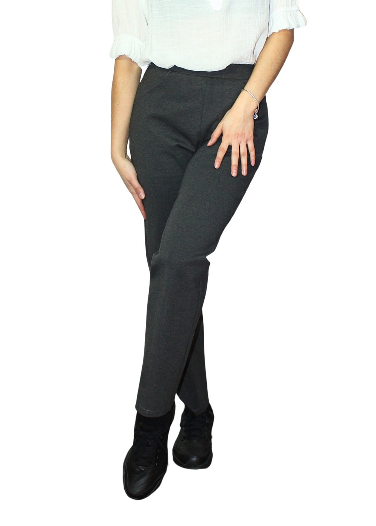 Person wearing dark gray pants and black shoes on a white background