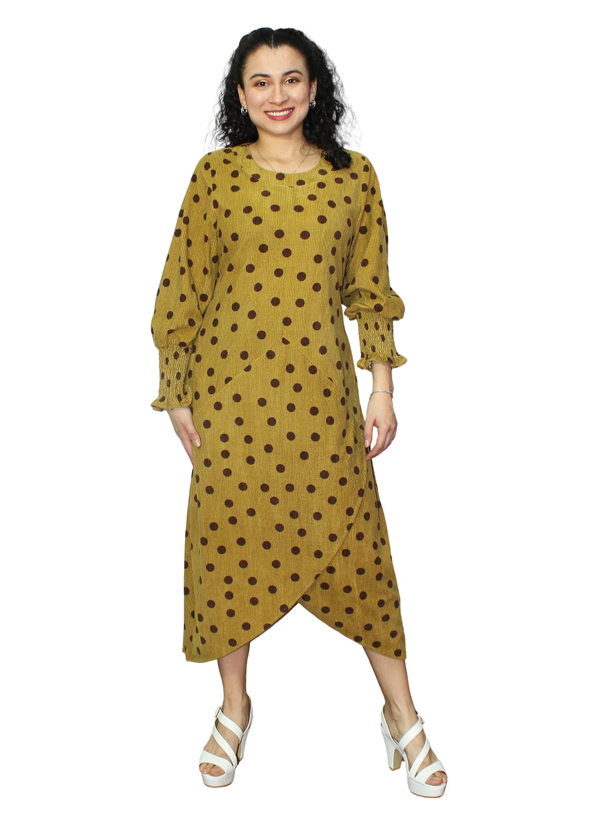 Woman wearing a mustard yellow dress with brown polka dots on a white background