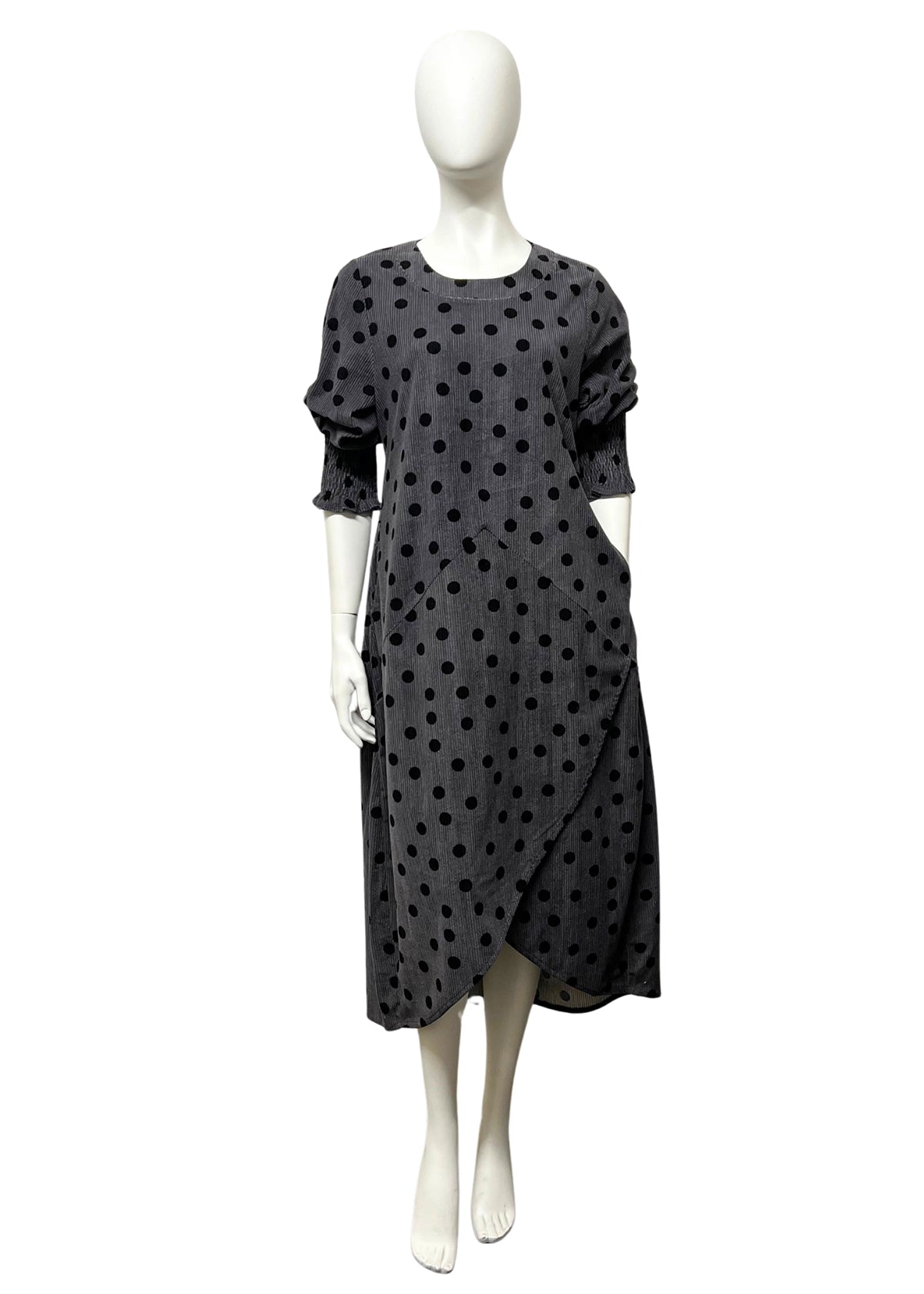 Black polka dot dress on a mannequin against a white background