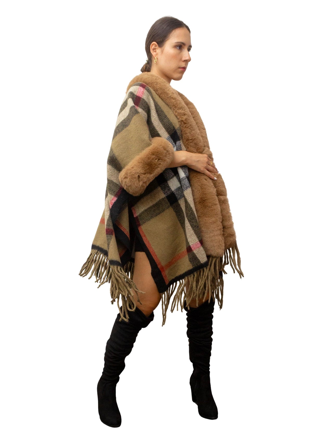 Woman wearing a checkered poncho with fur trim on a white background