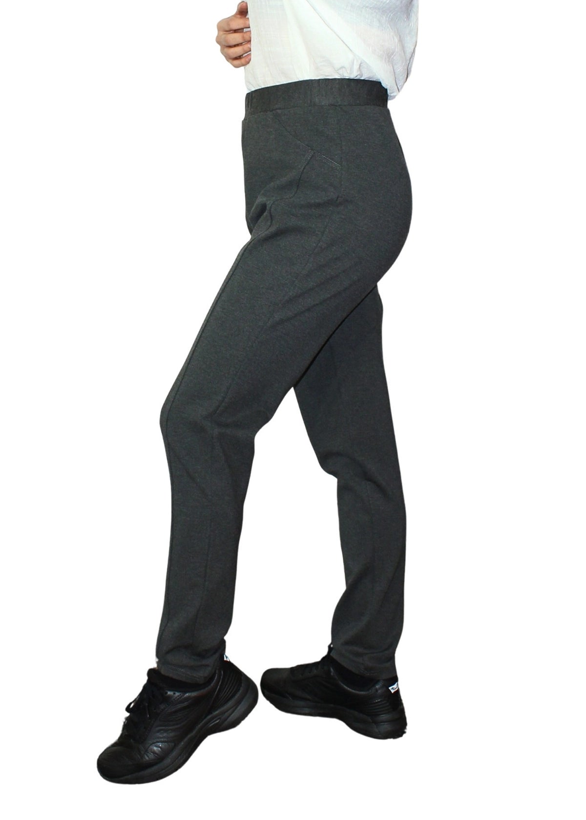 Dark gray pants worn by a person on a white background
