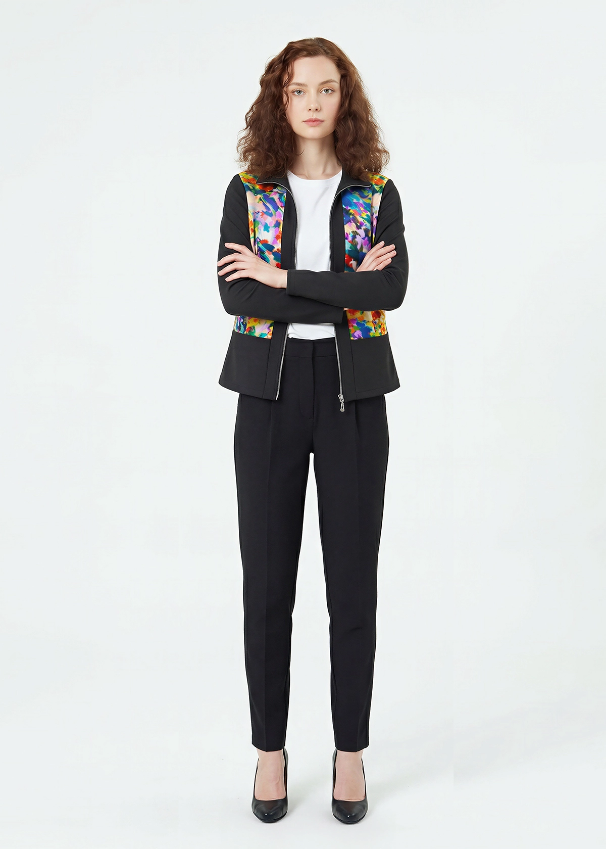 Woman wearing a black suit with a colorful floral pattern on a white background