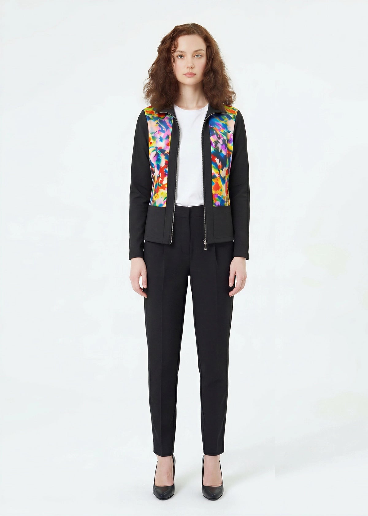 Person wearing a black outfit with colorful patterned vest on a white background