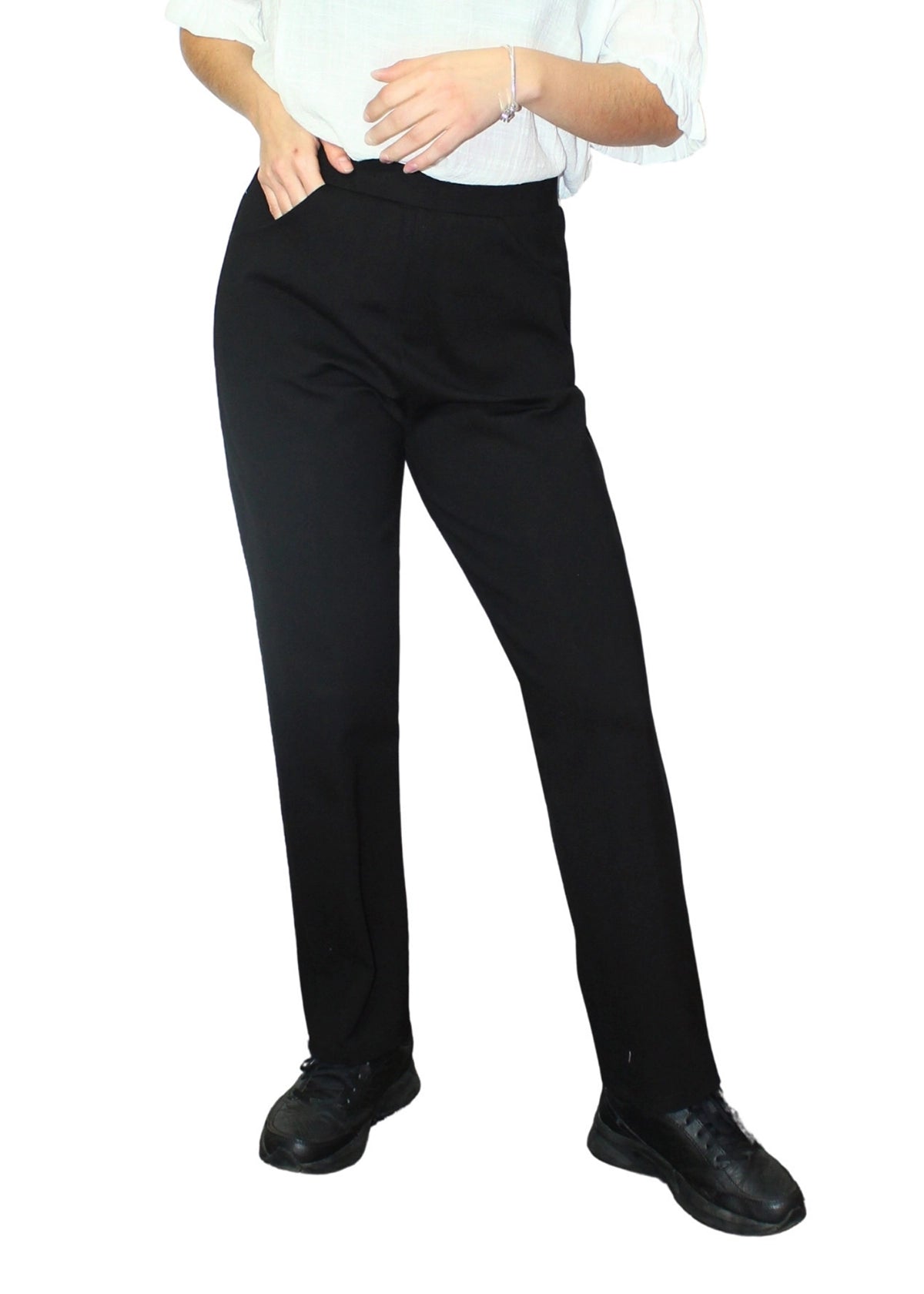 Person wearing black pants and black shoes on a white background