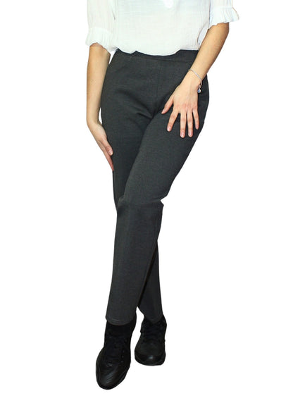 Person wearing dark gray pants and black shoes on a white background
