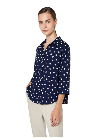 Woman wearing a navy blue shirt with white pattern on a white background