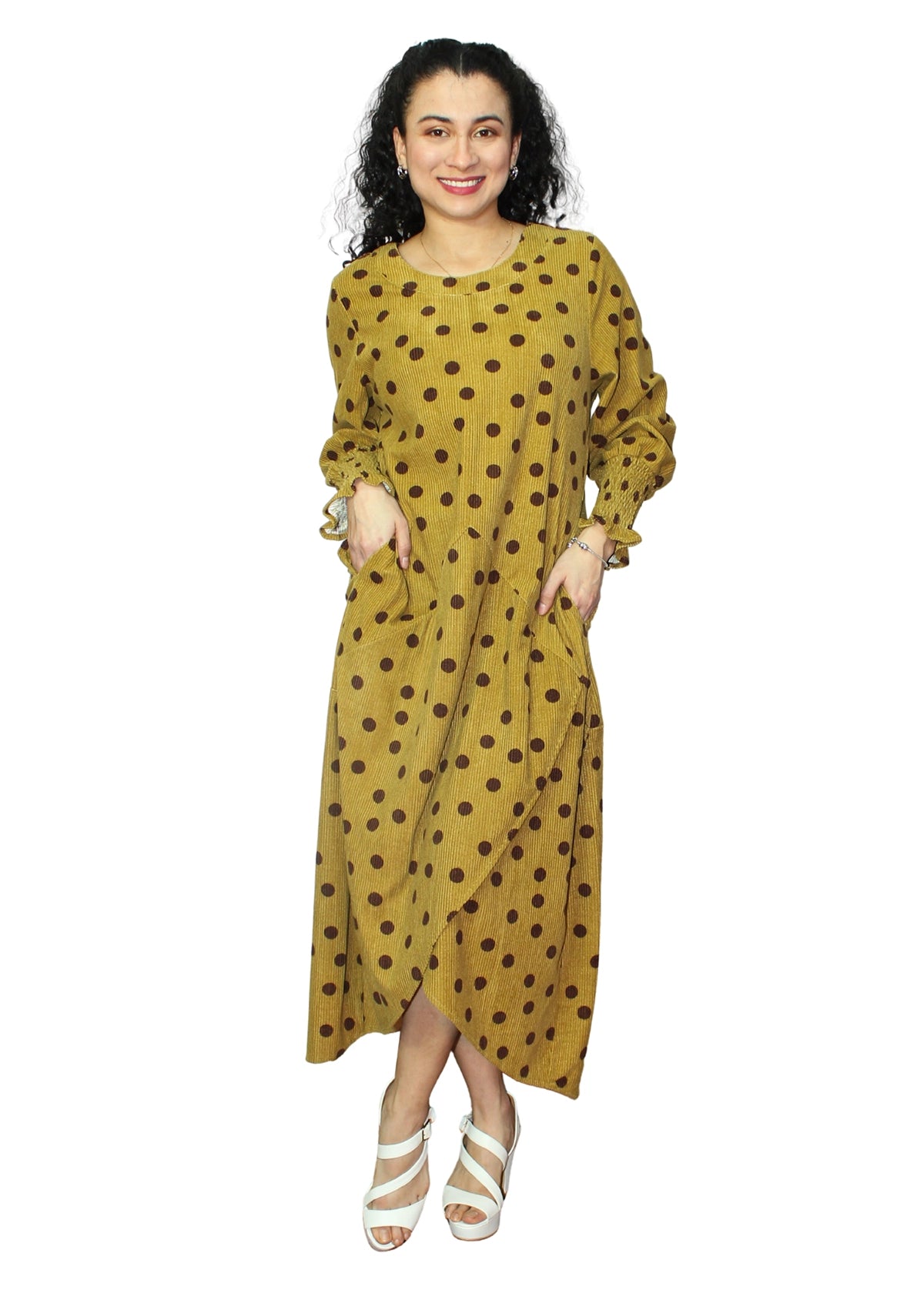 Woman wearing a yellow dress with brown polka dots on a white background