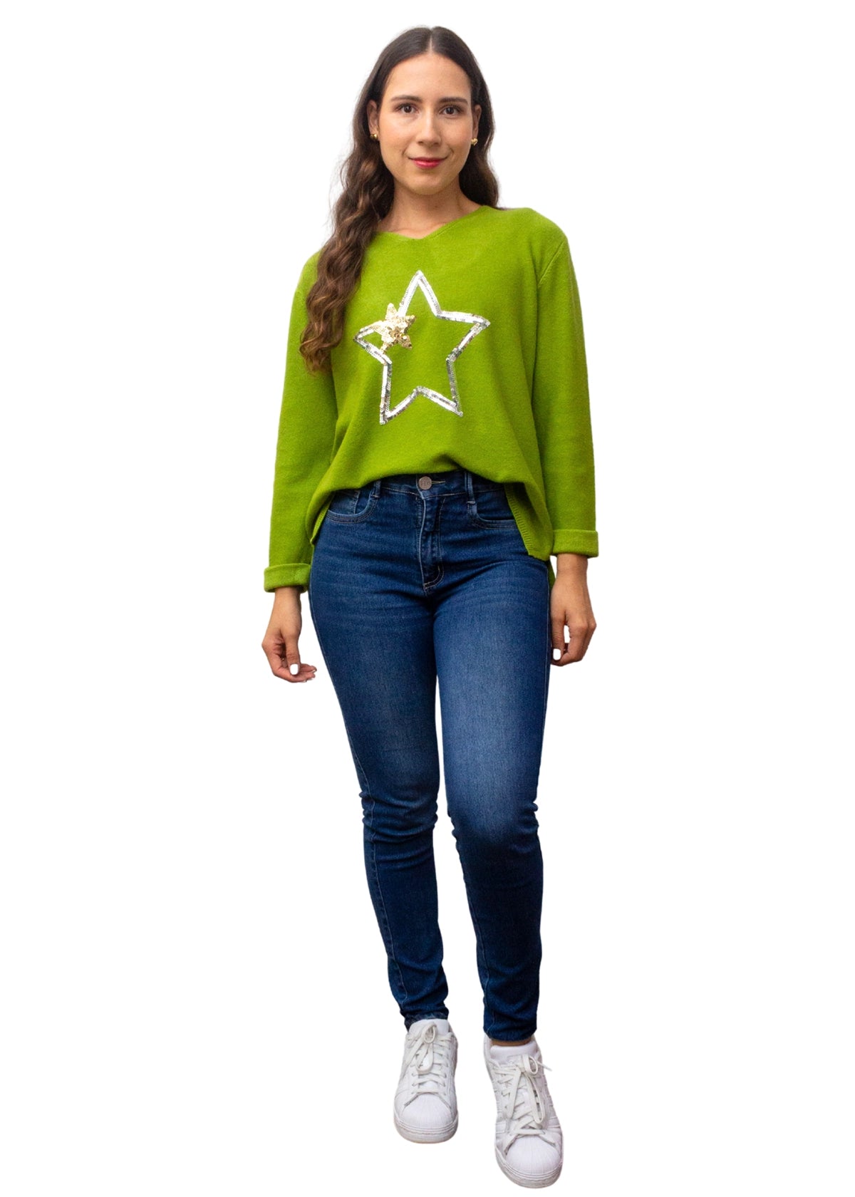 Woman wearing a green sweater with a star design and blue jeans on a white background