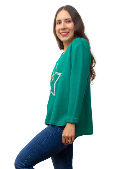 Woman wearing a green oversized shirt with a star design on a white background