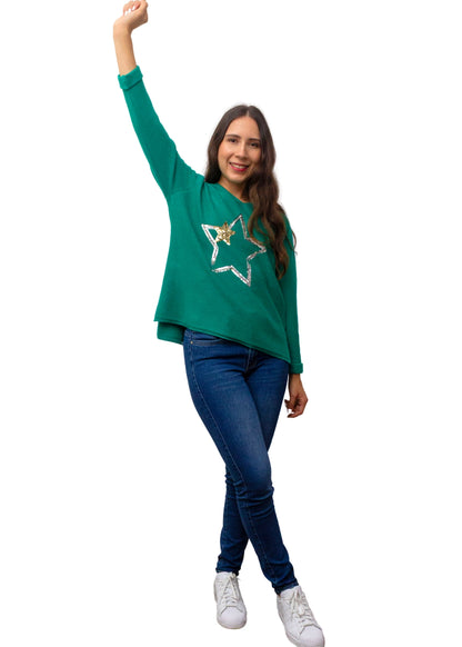 Woman wearing a green sweater with a star design on a white background