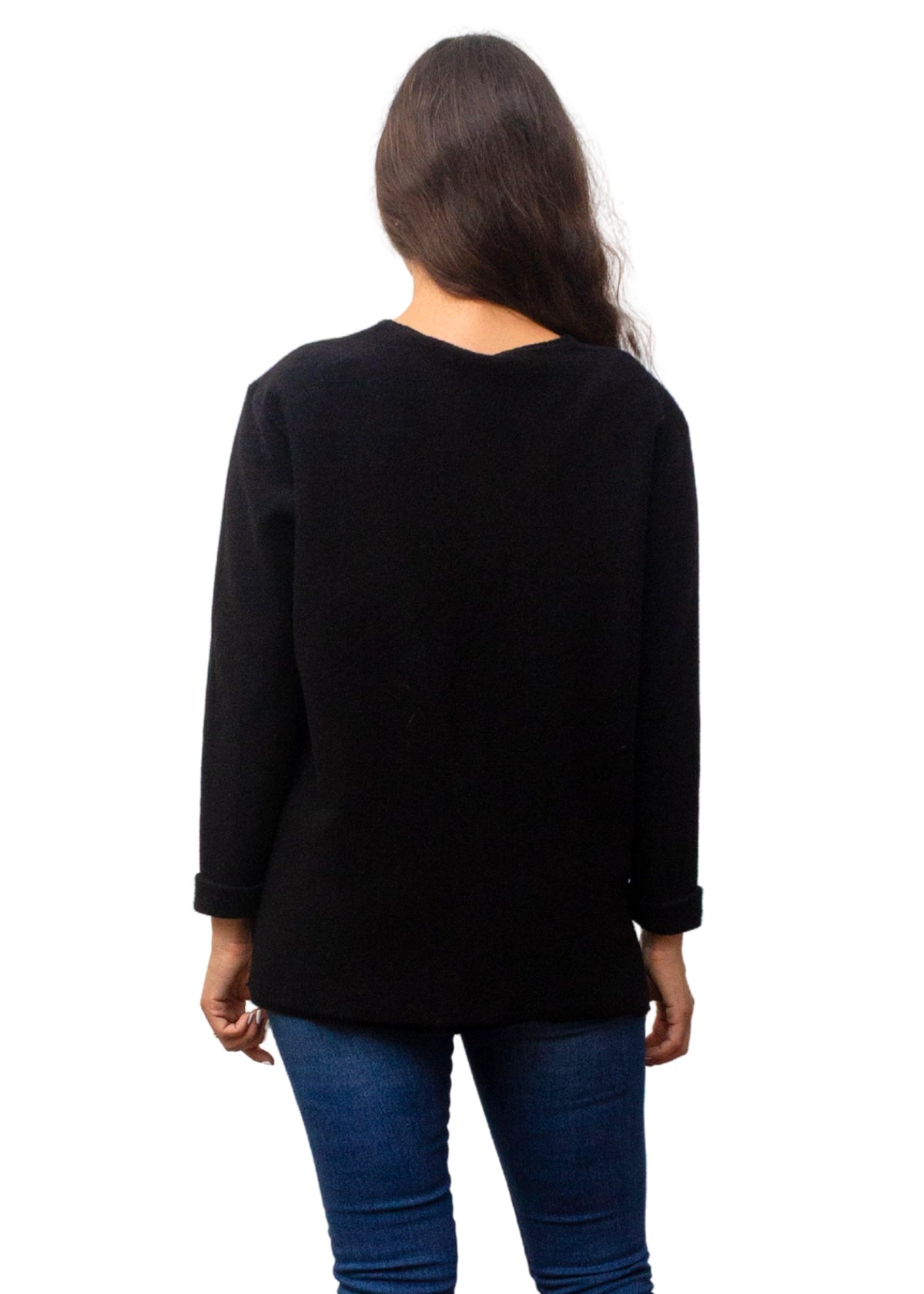 Person wearing a black long-sleeve top and blue jeans on a white background