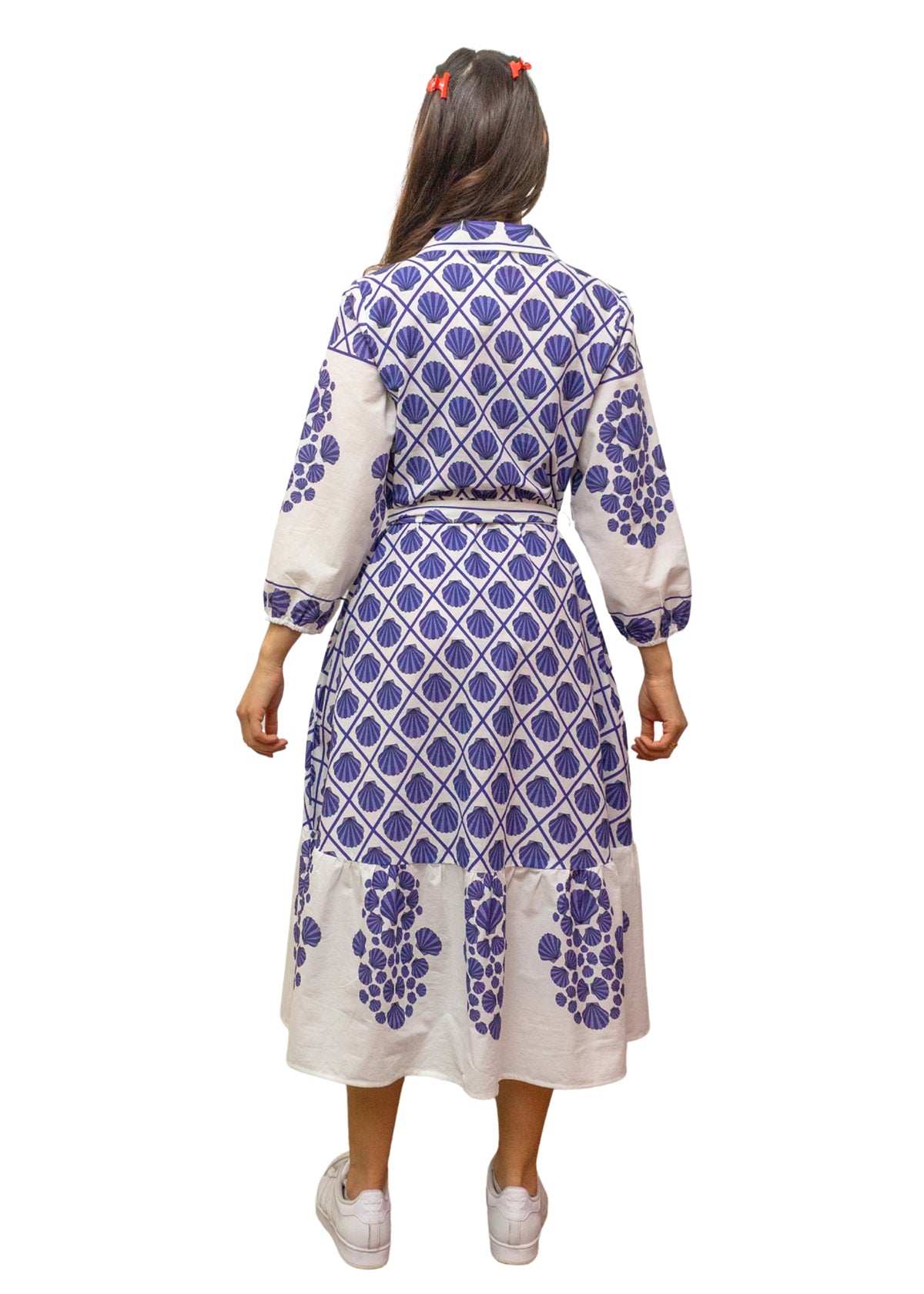 Woman wearing a blue and white patterned dress on a white background