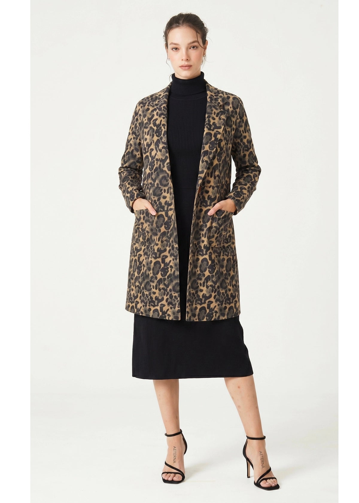 Woman wearing a leopard print coat on a white background