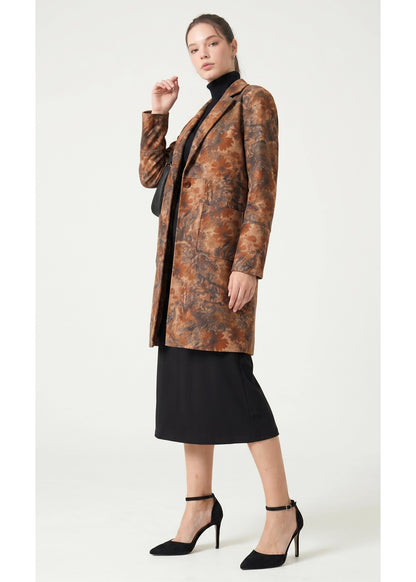 Woman wearing a patterned coat over a black outfit on a white background