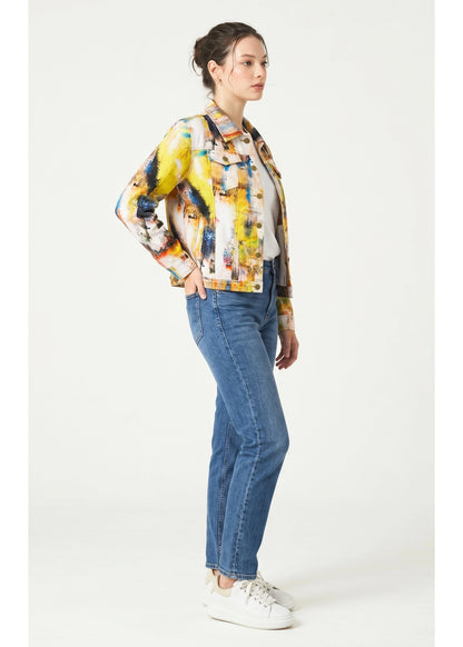 Woman wearing a colorful jacket and blue jeans on a white background