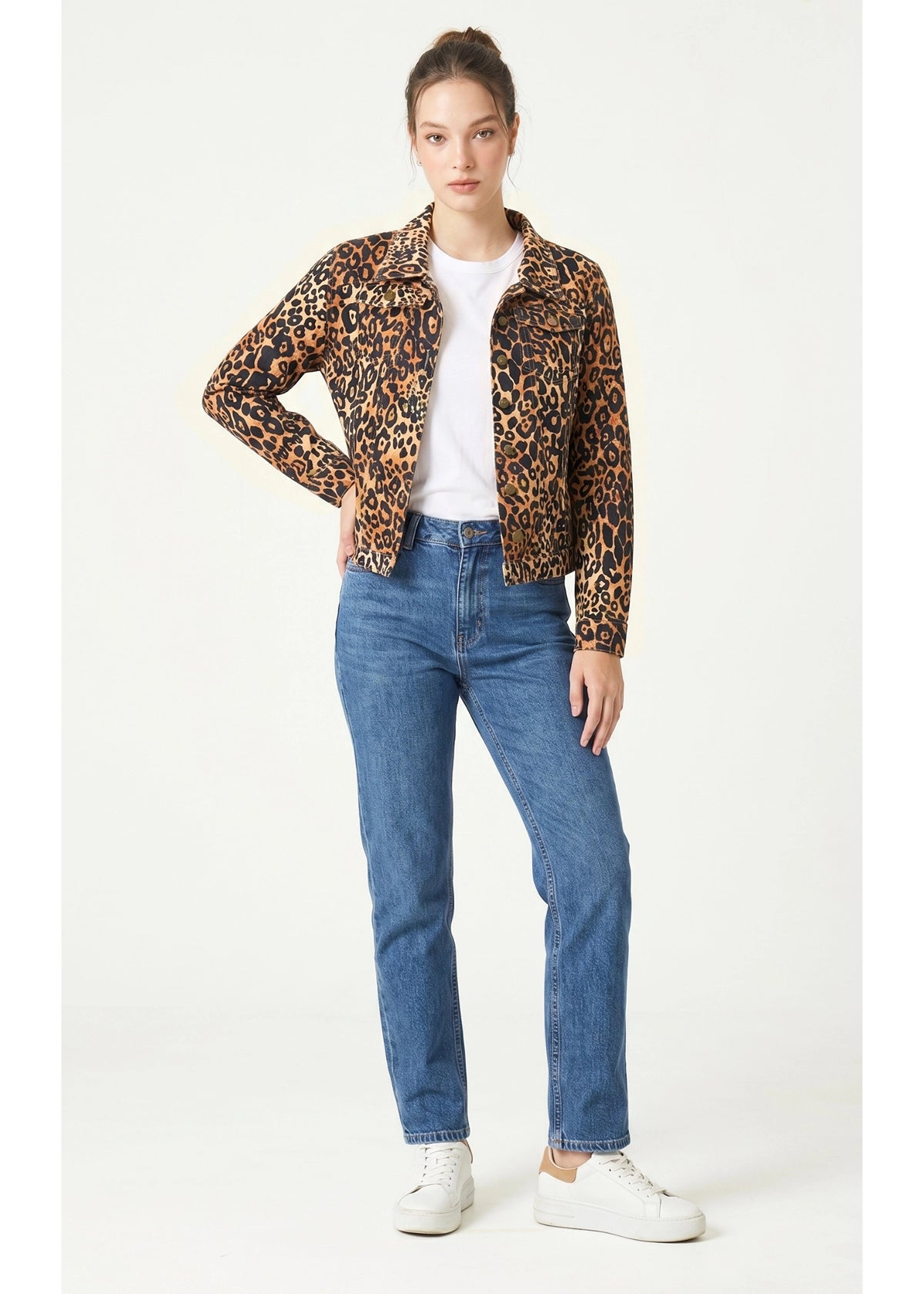 Person wearing a leopard print jacket, white shirt, blue jeans, and white sneakers on a white background
