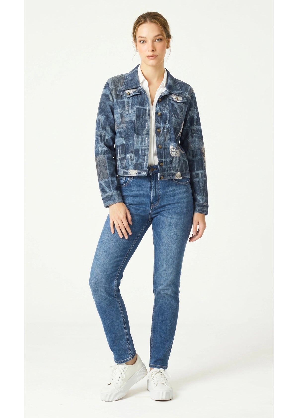 Woman wearing a patchwork denim jacket and jeans on a white background