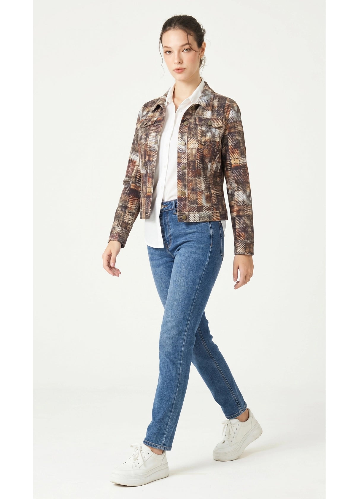 Woman wearing a plaid jacket, white shirt, blue jeans, and white sneakers on a white background