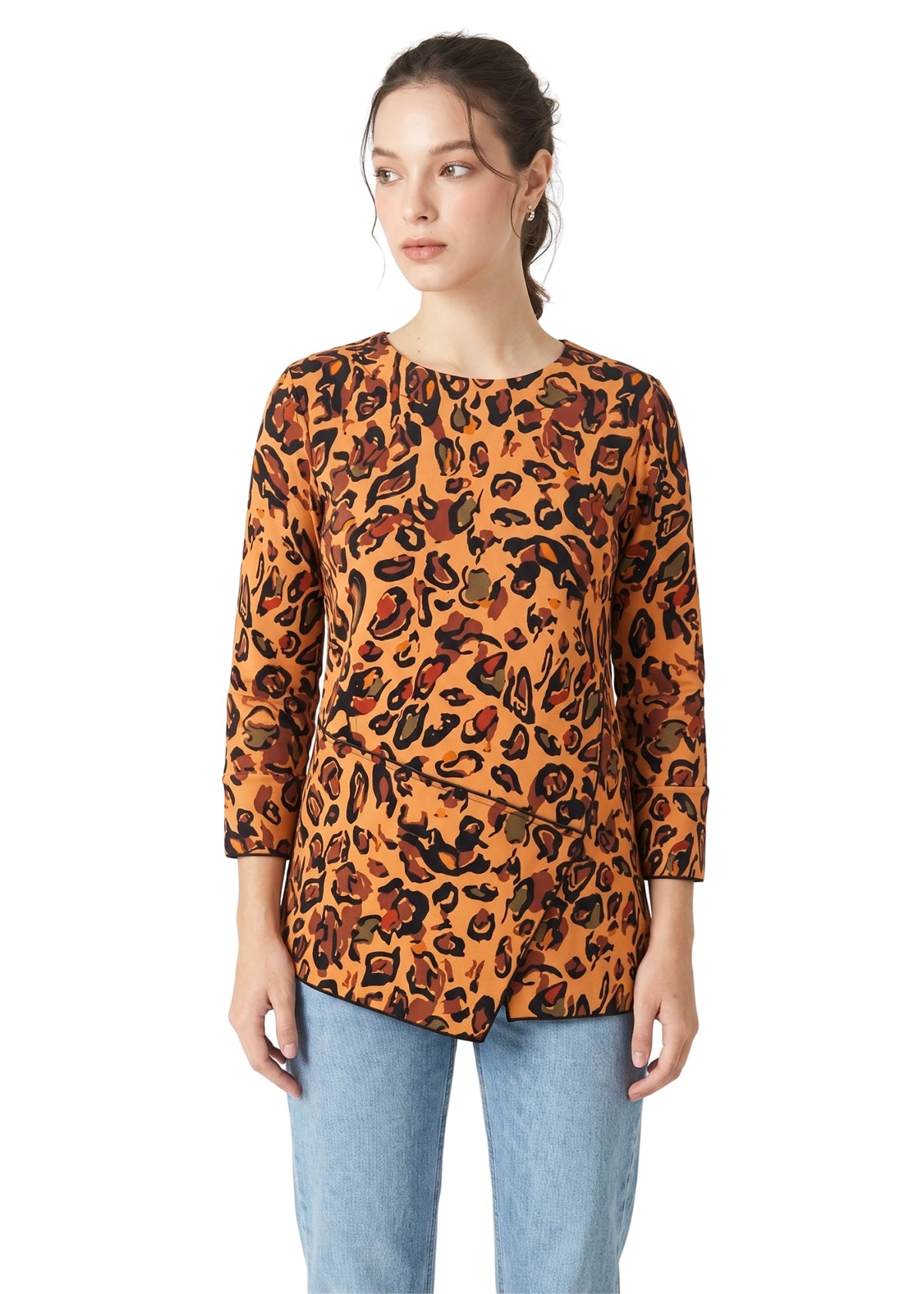 Woman wearing a leopard print top and light blue jeans on a white background