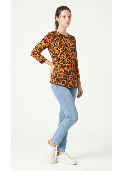 Woman wearing a leopard print top and light blue jeans on a white background