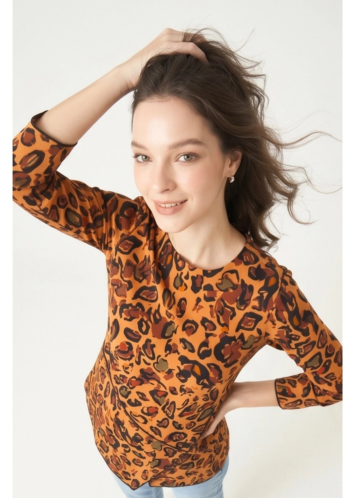 Woman wearing an orange leopard print top on a white background