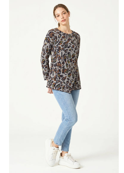 Woman wearing a leopard print top and light blue jeans on a white background