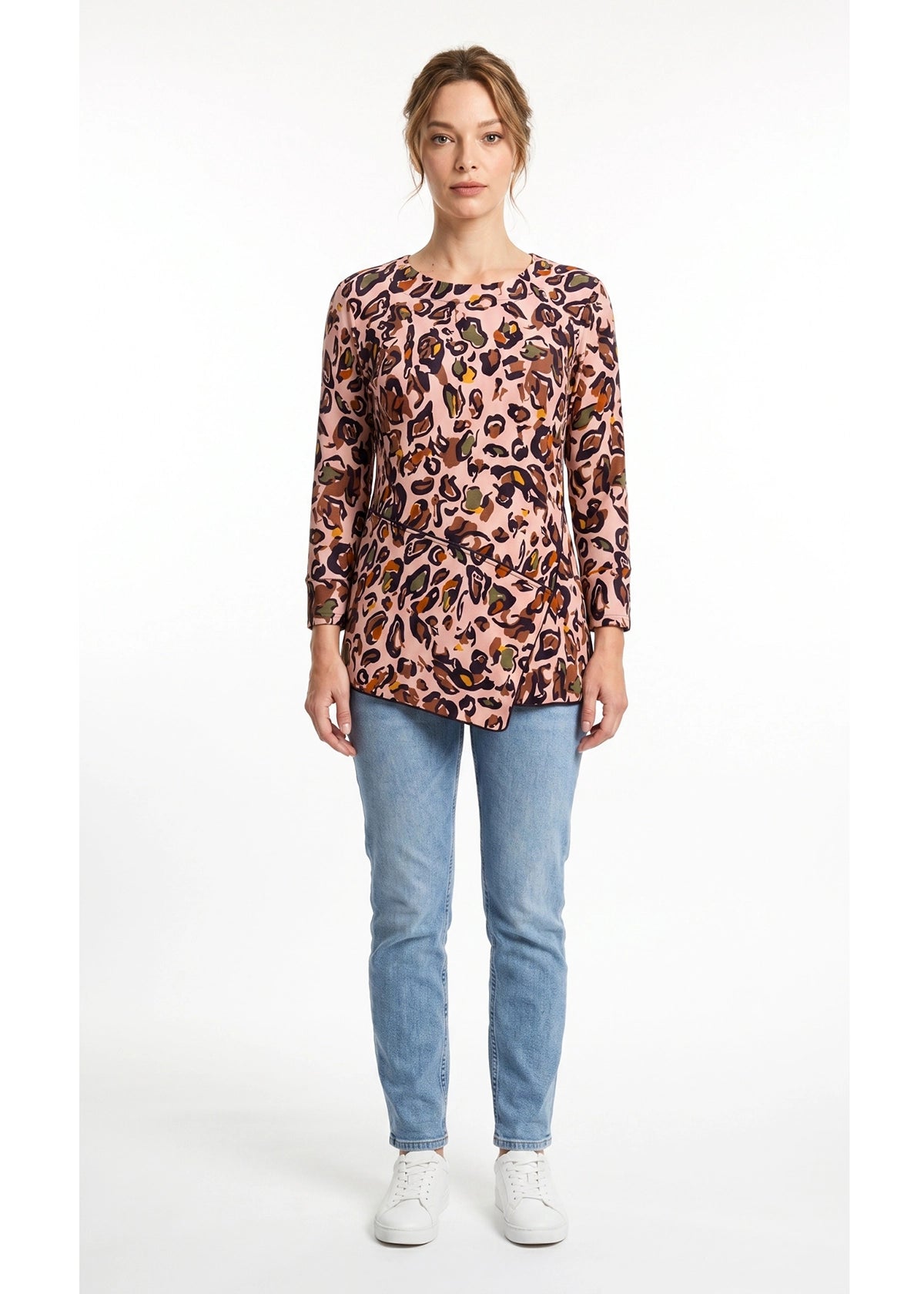 Woman wearing a leopard print top and blue jeans on a white background