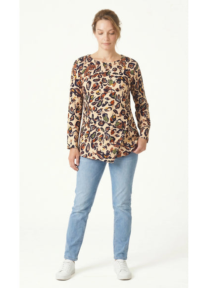 Woman wearing a leopard print top and light blue jeans on a white background