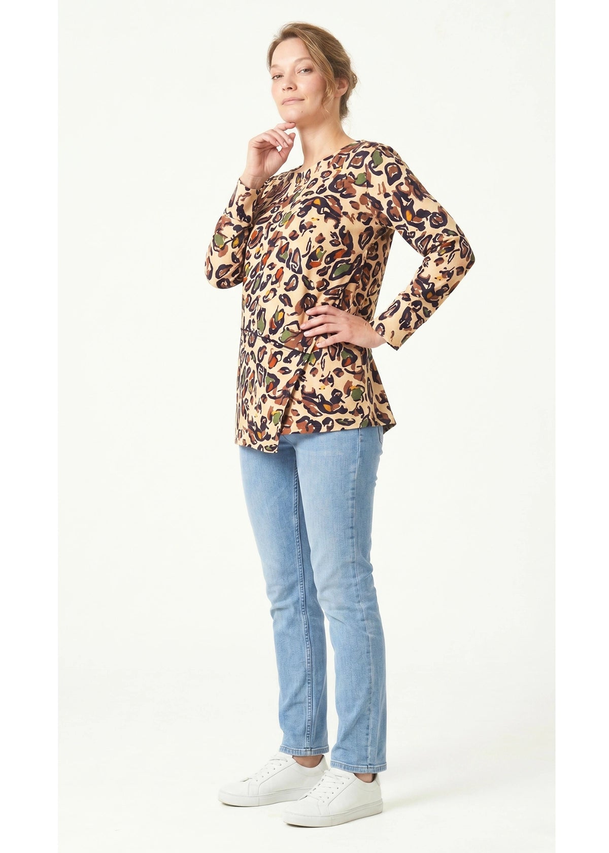 Woman wearing a leopard print top and blue jeans on a white background