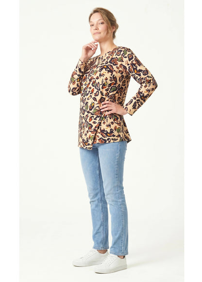 Woman wearing a leopard print top and blue jeans on a white background