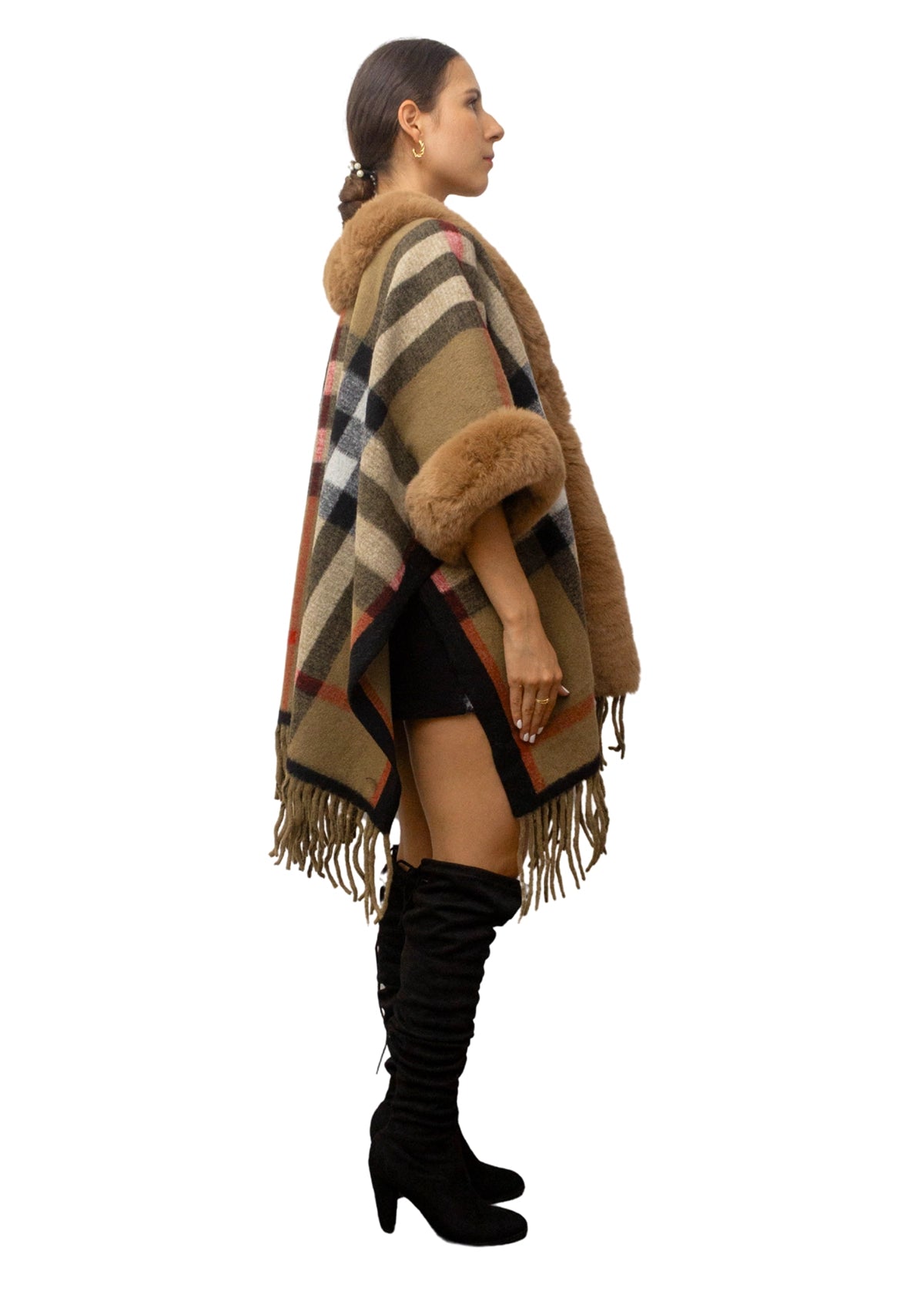 Woman wearing a plaid poncho with fur trim on a white background