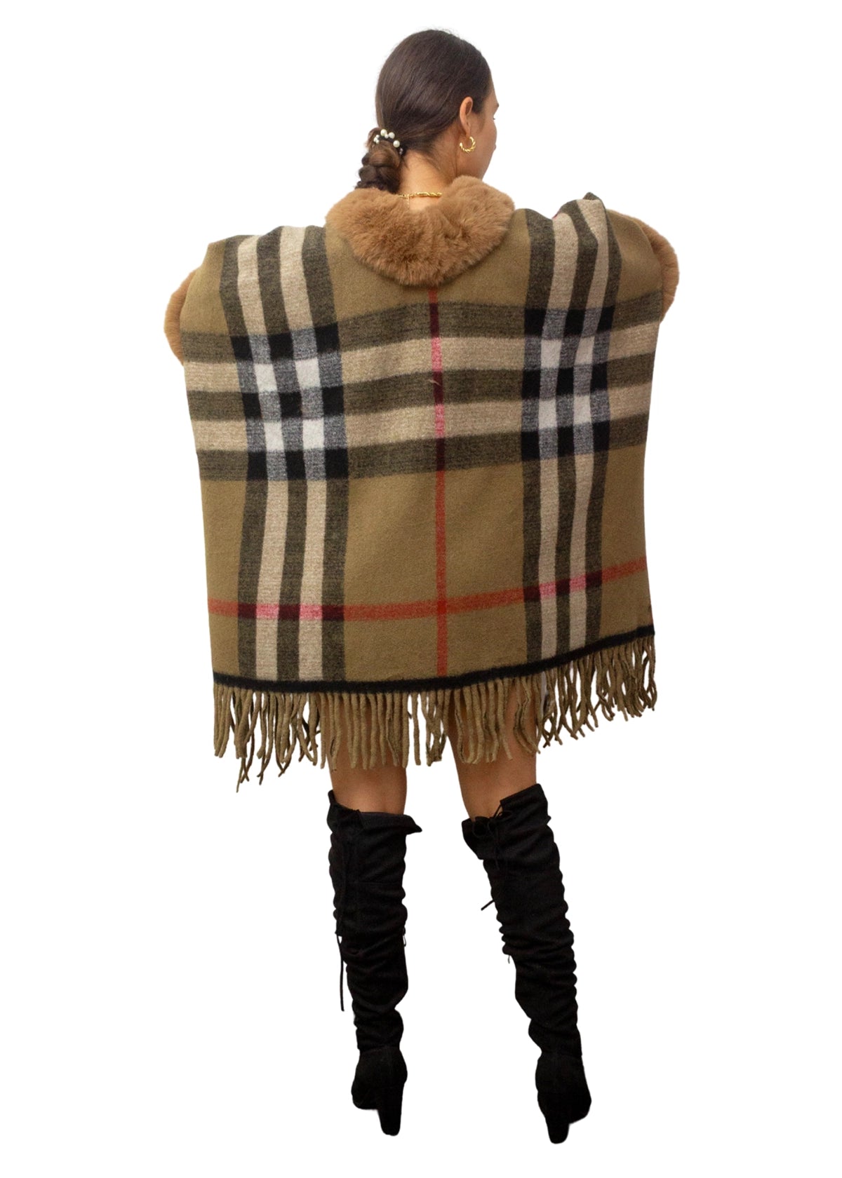 Person wearing a Burberry checkered poncho with fringes on a white background