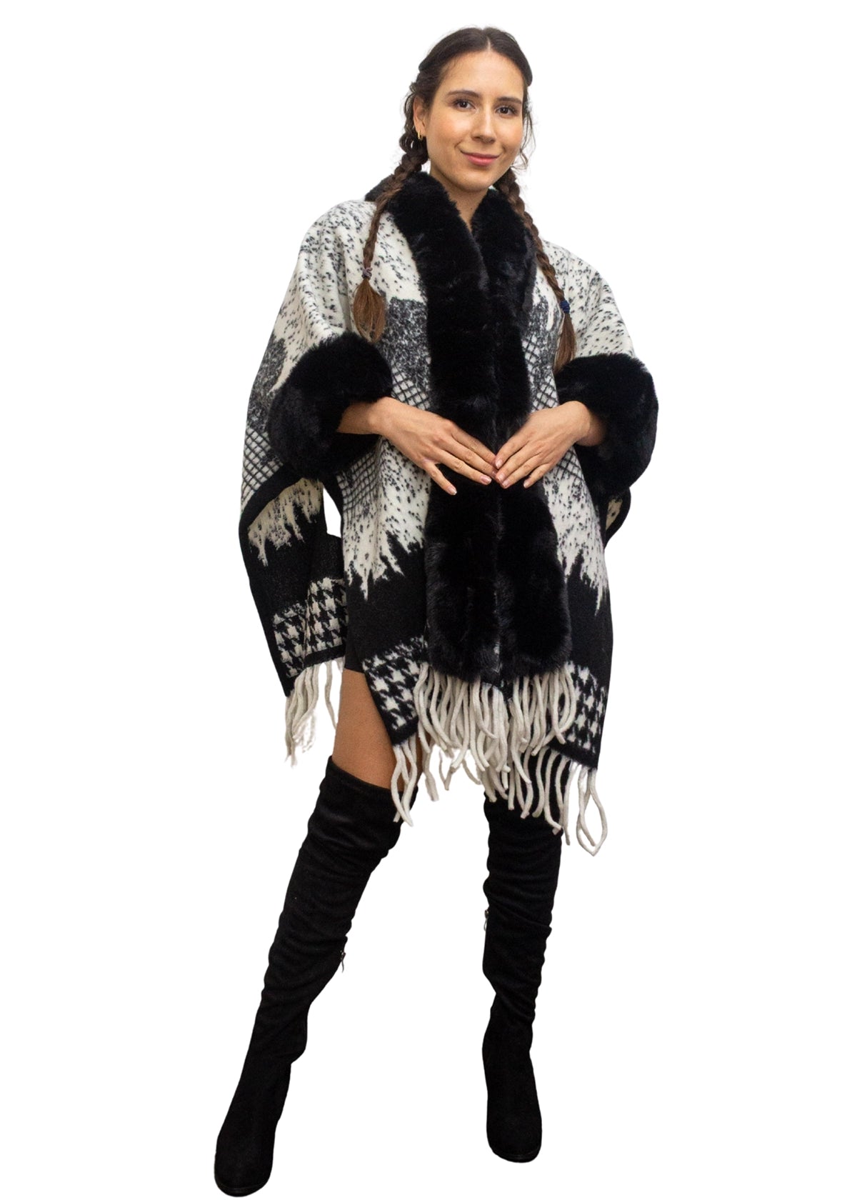 Woman wearing a black and white patterned poncho with fur trim on a white background