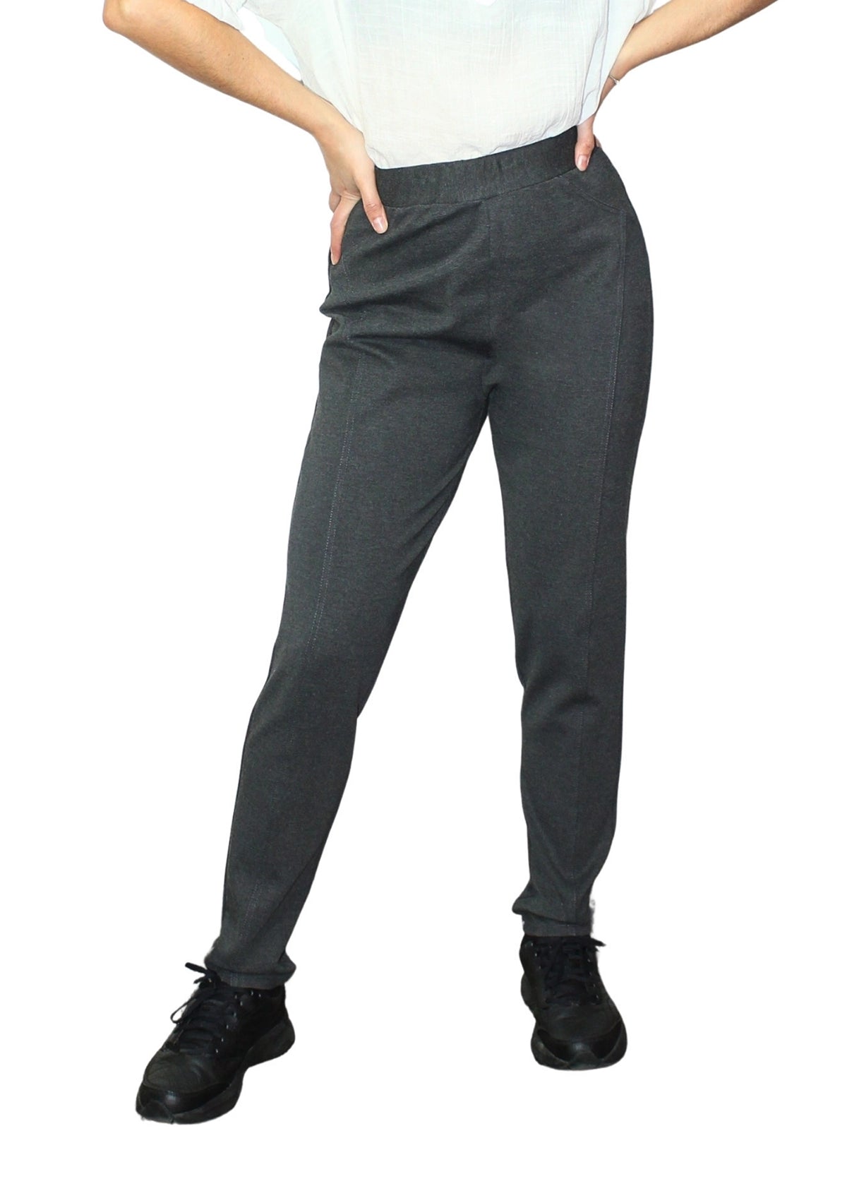 Person wearing gray pants and black shoes on a white background
